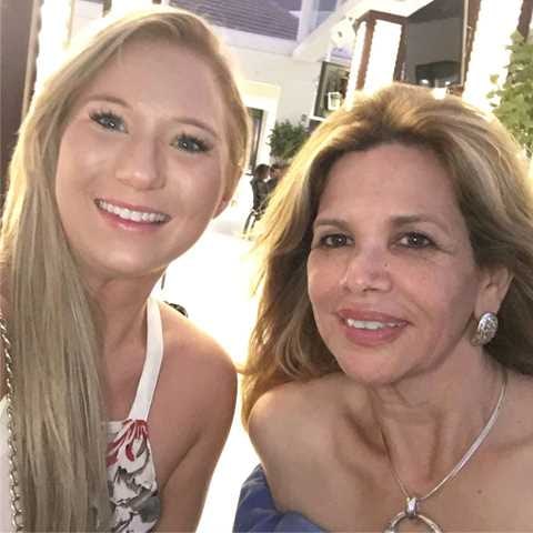 Close selfie of Xiomara smiling beside a young blonde woman.